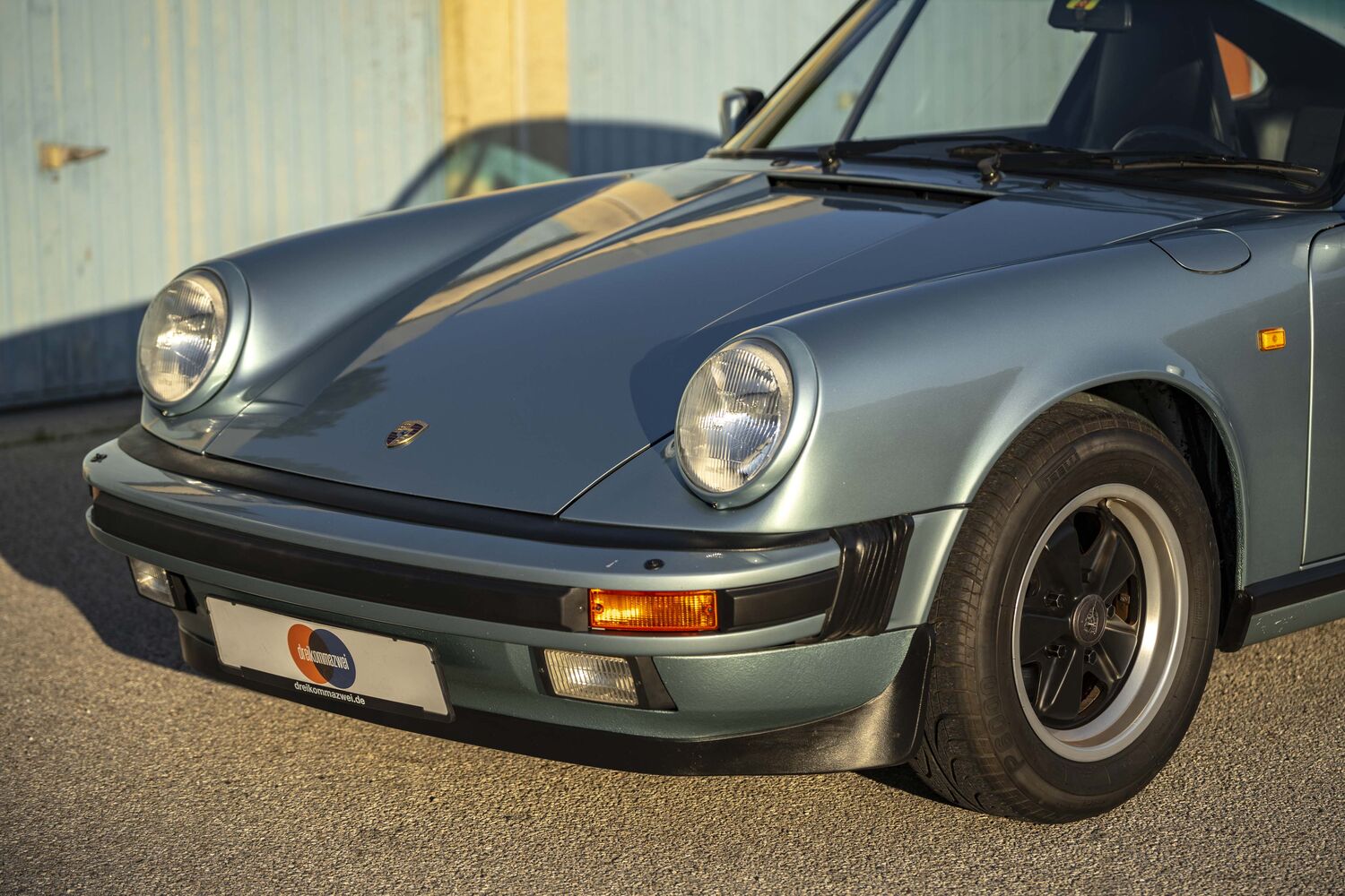 Frontpartie eines silberblauen Porsche 911 Carrera der G-Generation