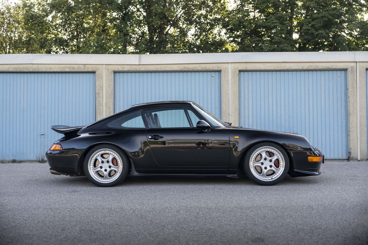 Schwarzer Porsche 911 der 993-Generation im Seitenprofil