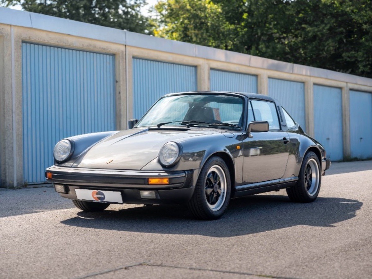 Metallic-grauer Porsche 911 Targa Oldtimer vor blauen Garagentoren