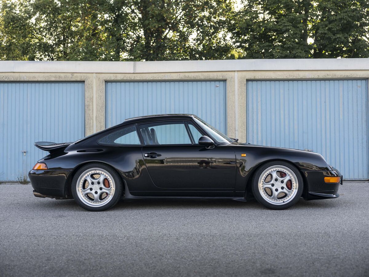 Schwarzer Porsche 911 der 993-Generation im Seitenprofil
